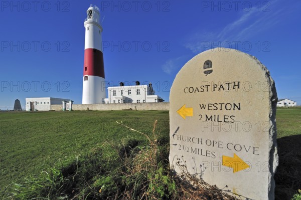 Portland Bill lighthouse and stone waymarker on the Isle of Portland along the Jurassic Coast,