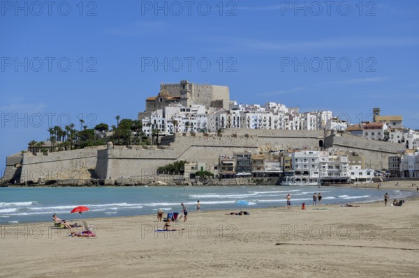 Bathers at the Playa de Peñíscola, beach, against the backdrop of the old town, Peñíscola, province