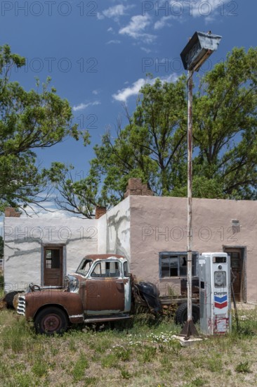 La Jara, Colorado, A rusty, old pickup truck, parked in front of an old Chevron gas station, in