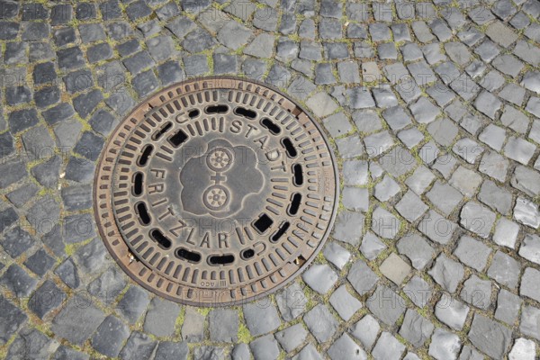 Manhole cover with city coat of arms and inscription, city, paving stones, market place, Fritzlar,