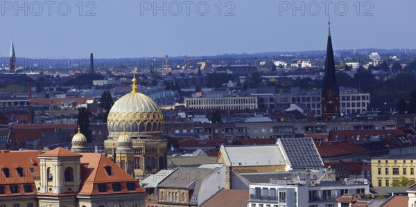 The tambour dome of the New Synagogue covered in gilded ribs in the city panorama, Berlin, Germany,