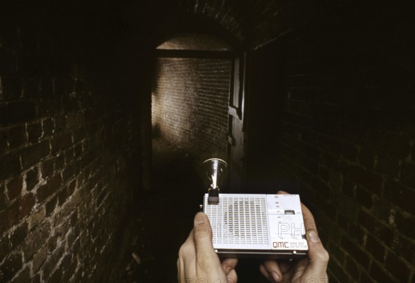 Man using bat detector in old cellar, icehouse for research
