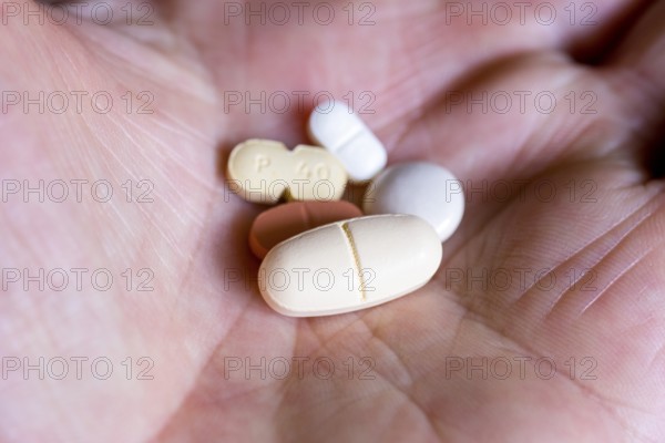 Hand holds various tablets, medicines