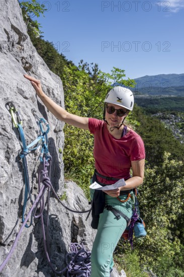 Climber on the rope looking at the topo, multi-pitch climbing, Via la Bellezza della Venere, Garda