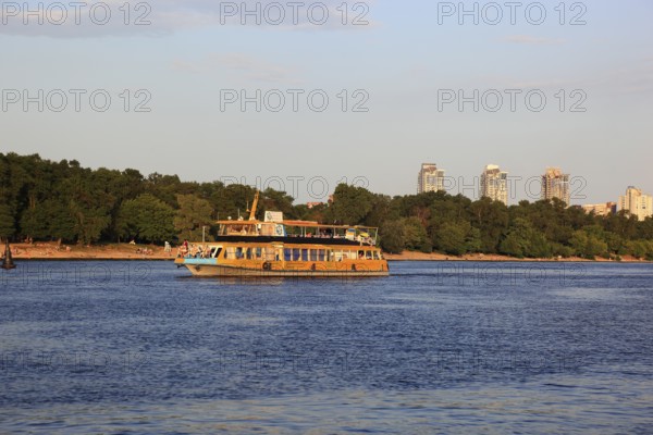 Excursion boat on the river Dnepr and skyscrapers in the background, Kiev, Ukraine, Europe