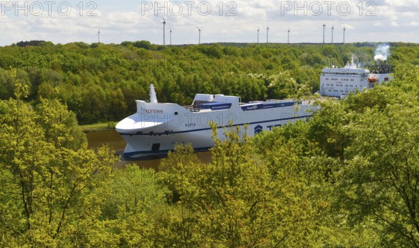 Car transporter, container ship in the forest on the Kiel Canal, Schleswig-Holstein, Germany,