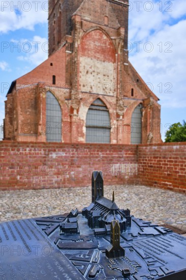 Cast miniature model of St. Mary's Church with the tower of the original in the background,