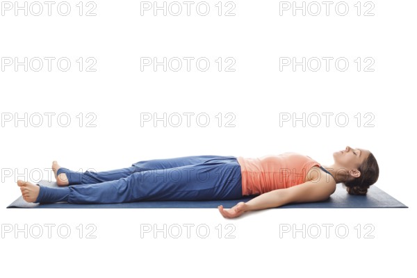 Beautiful sporty fit yogini woman relaxes in yoga asana Savasana, corpse pose isolated on white