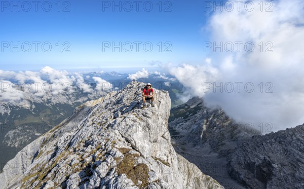 Mountaineer on a rocky narrow mountain path with mountain panorama, mountain tour to the summit of