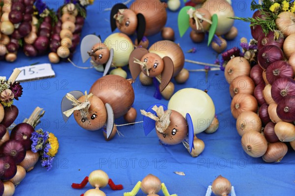 Market stall with onions in the shape of an elephant and onion plaits with traditional harvest