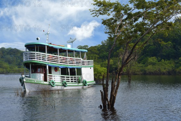Traditional Amazonian wooden boat navigating on the Rio Negro, Manaus, Amazonia State, Brazil,