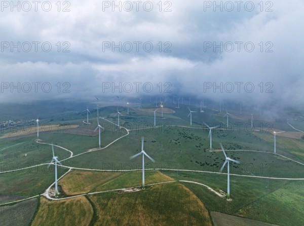 Windmills on a wind farm near Zahara de los Atunes, at a cloudy dawn, aerial view, drone shot,