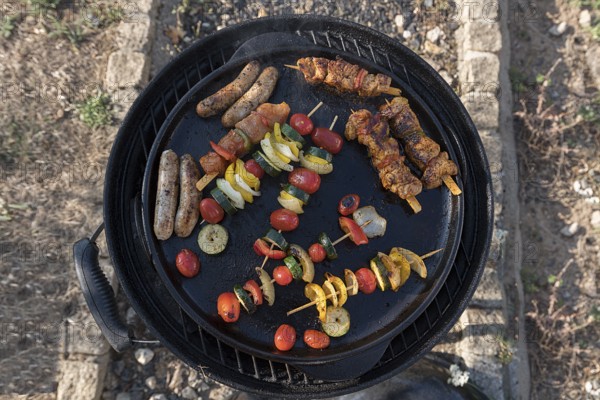 Bratwurst, meat and vegetable skewers in a grill pan, Bavaria, Germany, Europe
