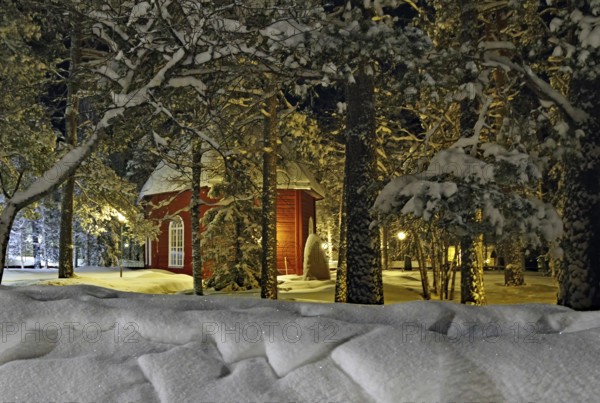 Old church in Jokkmokk in winter, red wooden building, snow-covered trees, Lapland, Sweden, Europe
