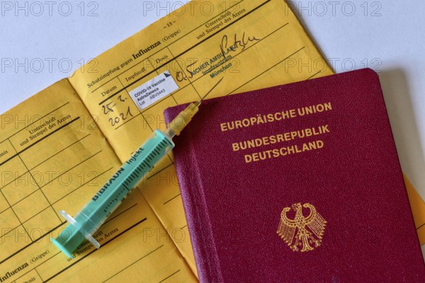 Passport, syringe and vaccination certificate with entry for vaccination with AstraZeneca against