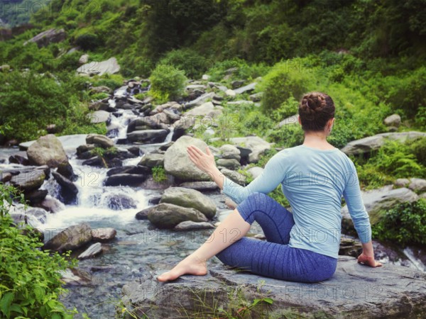 Yoga exercise outdoors, woman doing Ardha matsyendrasana asana, half spinal twist pose at tropical