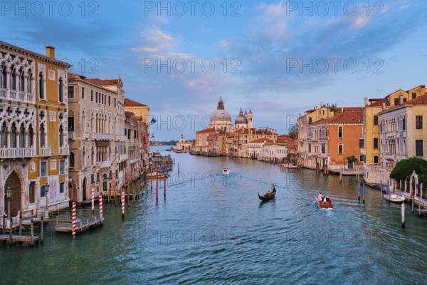 Panorama of Venice Grand Canal with boats and Santa Maria della Salute church on sunset from Ponte