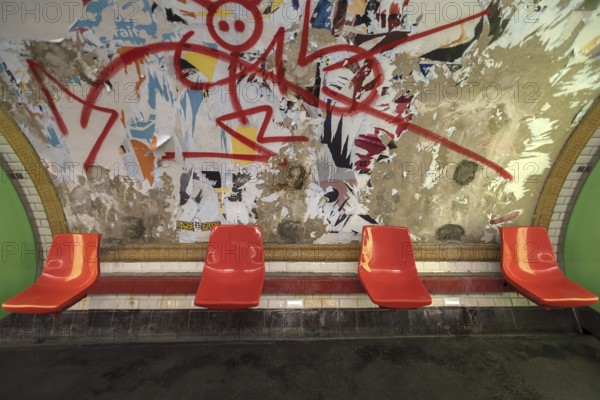 Red seats in the metro in front of a torn down billboard, Paris, France, run down, graffiti, Europe