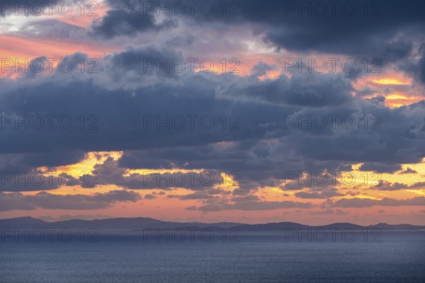 Dramatic cloudy sky at sunrise over the sea, Aegean Sea, Syros, Cyclades, Greece, Europe