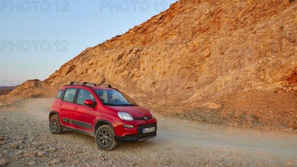 Morning light, red Fiat Panda 4x4, driving track, reddish rock, Gramvoussa peninsula, Pirate Bay,