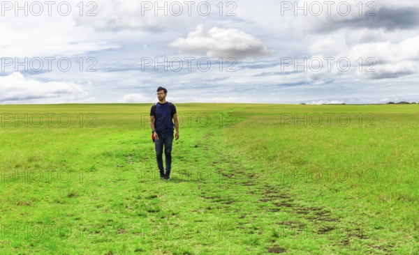 Traveler man walking in the beautiful countryside. Backpacker man walking in a countryside.