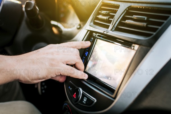 Driver hands changing the radio station. Close up of hands changing the car radio station. Concept