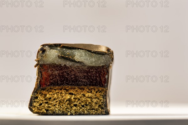 Single halved domino, Christmas sweet with layers of marzipan, gingerbread and dark chocolate