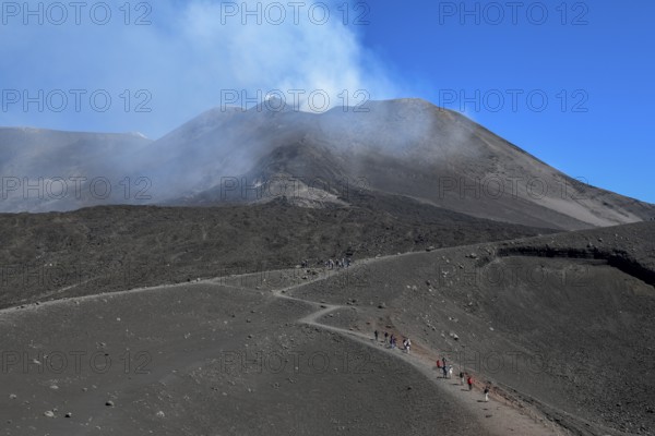 Hikers in the crater landscape of the volcano Etna, summit region, province of Catania, Sicily,