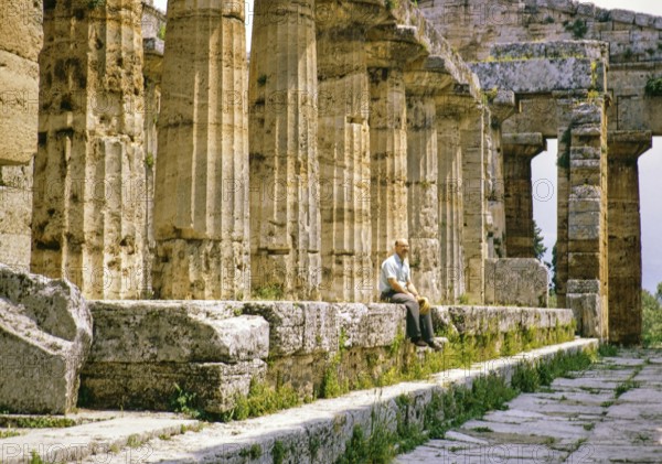 Man sitting inside Temple of Hera II, also known as the Temple of Neptune, Paestum archaeological