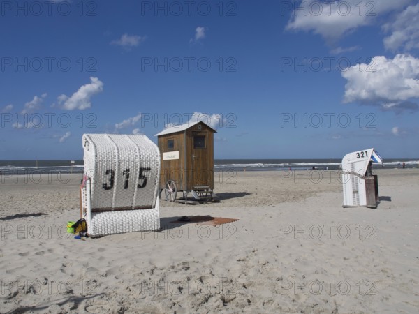 Beach chairs and a wooden hut stand side by side on the quiet beach, spiekeroog, east frisia, north