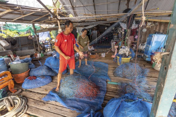 Fishermen repairing their nets, Ban Ao Salad fishing village, Ko Kut island or Koh Kood island in