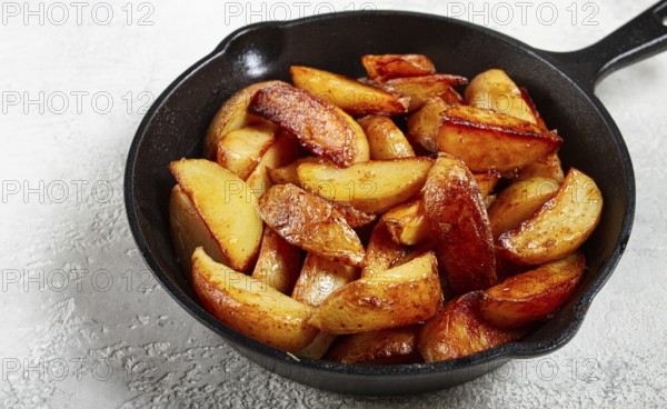Fried potato slices, in a cast-iron pan, homemade, no people