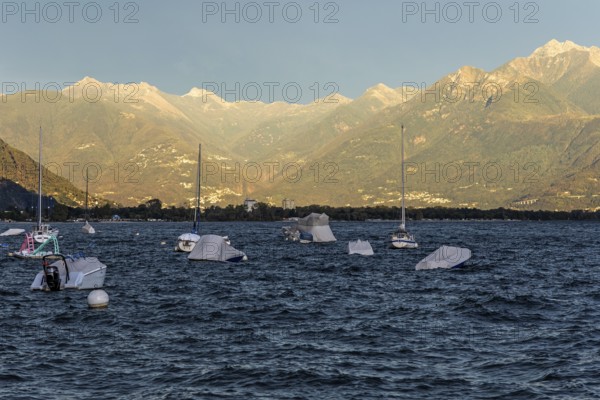 Boats lying in the water, Locarno, Lake Maggiore, surrounding mountains in the evening light,