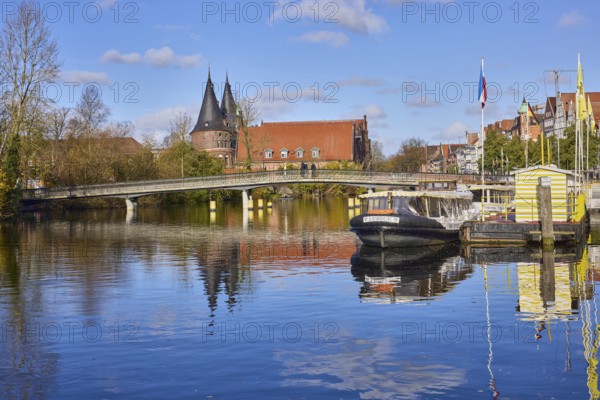 River Trave, pedestrian bridge Obertravebrücke, Holstentor, blue sky with fair weather clouds,