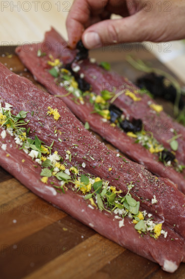 Swabian cuisine, preparation of lamb with prunes, raw lamb stuffed with herbs, rosemary, sliced