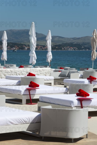 White deckchairs with red towels on the coast overlooking the sea, Amadria Park, En Vogue Beach