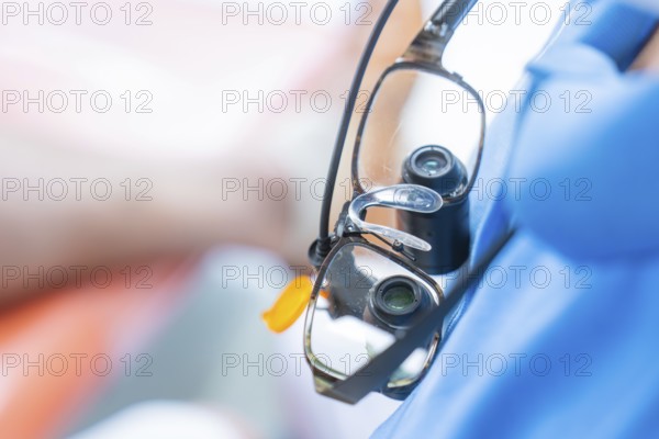 Close-up of medical magnifying glasses worn over a blue gown, dental practice, Germany, Europe