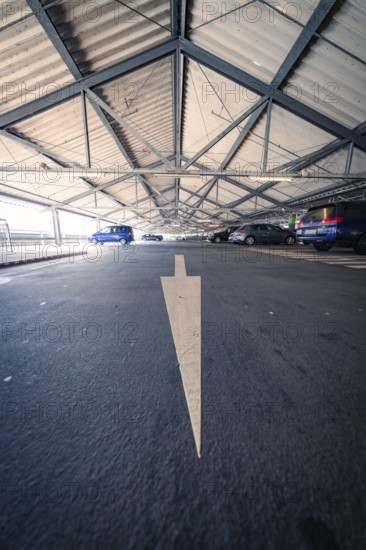 Car park with a painted arrow on the floor and parked cars, Kaufland Calw car park, Calw district,