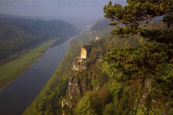 The bright lit Wartturm above the Elbe river seen from the Bastei rocks near the village of Rathen