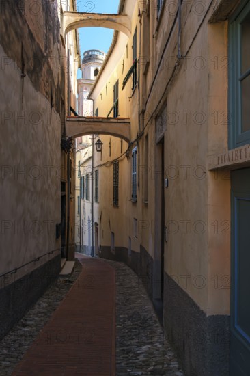 Picturesque narrow alley in the historic town centre with a view of the tower of the baroque church