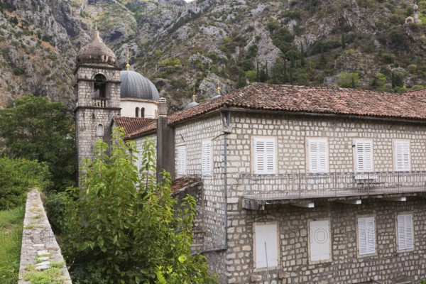 Old two storey stone building with white storm shutters on windows and covered with traditional