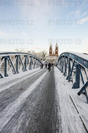 Bridge with snow and ice and cyclists, Blue Bridge and Stühlinger Church, Freiburg im Breisgau,