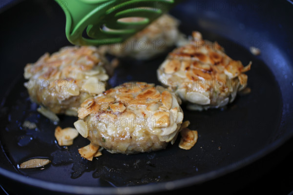 Swabian cuisine, meatballs wrapped in almonds, mixed minced meat, frying meatballs in fat, pan,