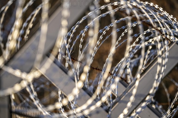 Symbolic image security, S-wire rolls, NATO wire, on a fence top, demarcation of a property,