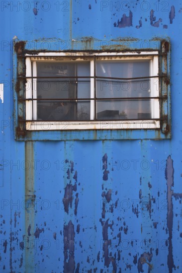 Blue painted metal building with window protected with steel bars, Quebec, Canada, North America