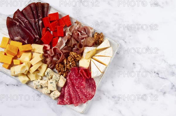 Assortment of cheese meat cuts, on a plate, top view, no people