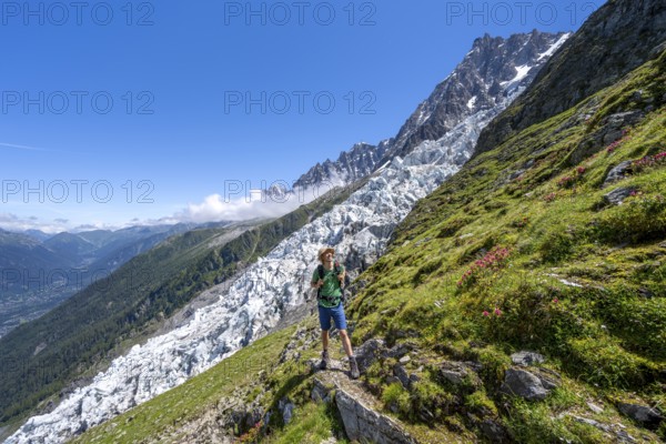 Hiking on the trail to La Jonction, Glacier des Bossons, behind the summit of the Aiguille du Midi,