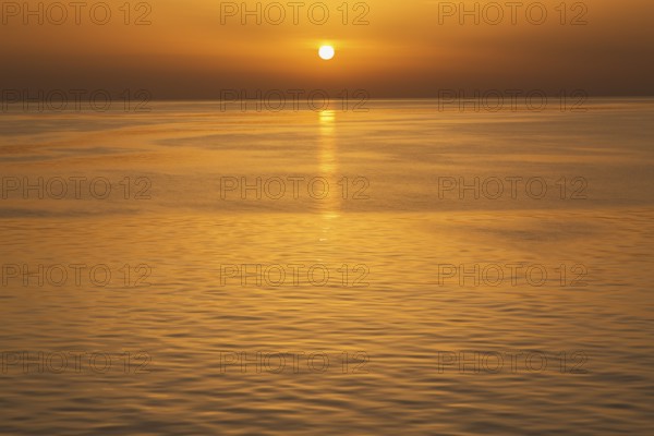 Setting golden sun over Adriatic sea taken from the top deck of a cruise ship in late summer, near