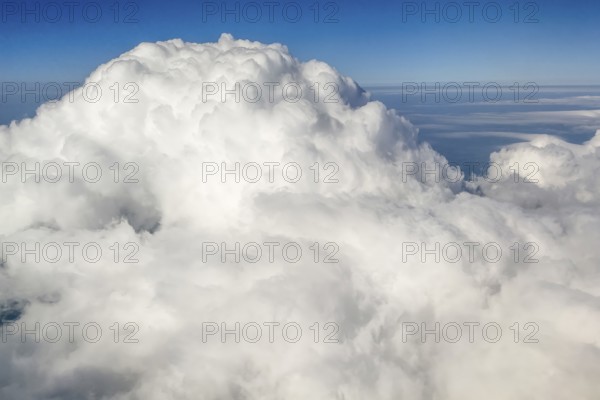 View from at 11887 metres 39000 feet altitude on top dome of large giant white cumulonimbus cloud,