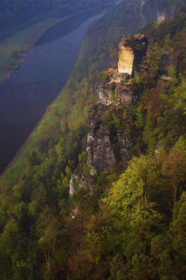 The bright lit Wartturm above the Elbe river seen from the Bastei rocks near the village of Rathen
